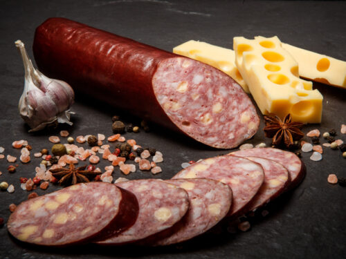 Delicatessen,sliced,cheddar,summer,sausage,with,sliced,pieces,served,with