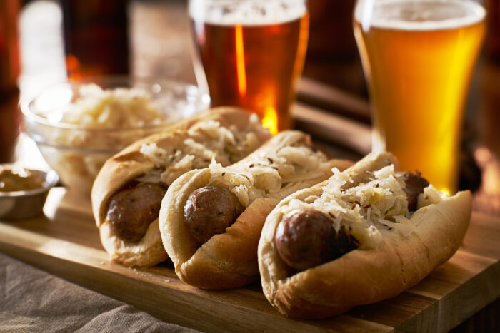 Three,german,bratwursts,and,sauerkraut,with,beer