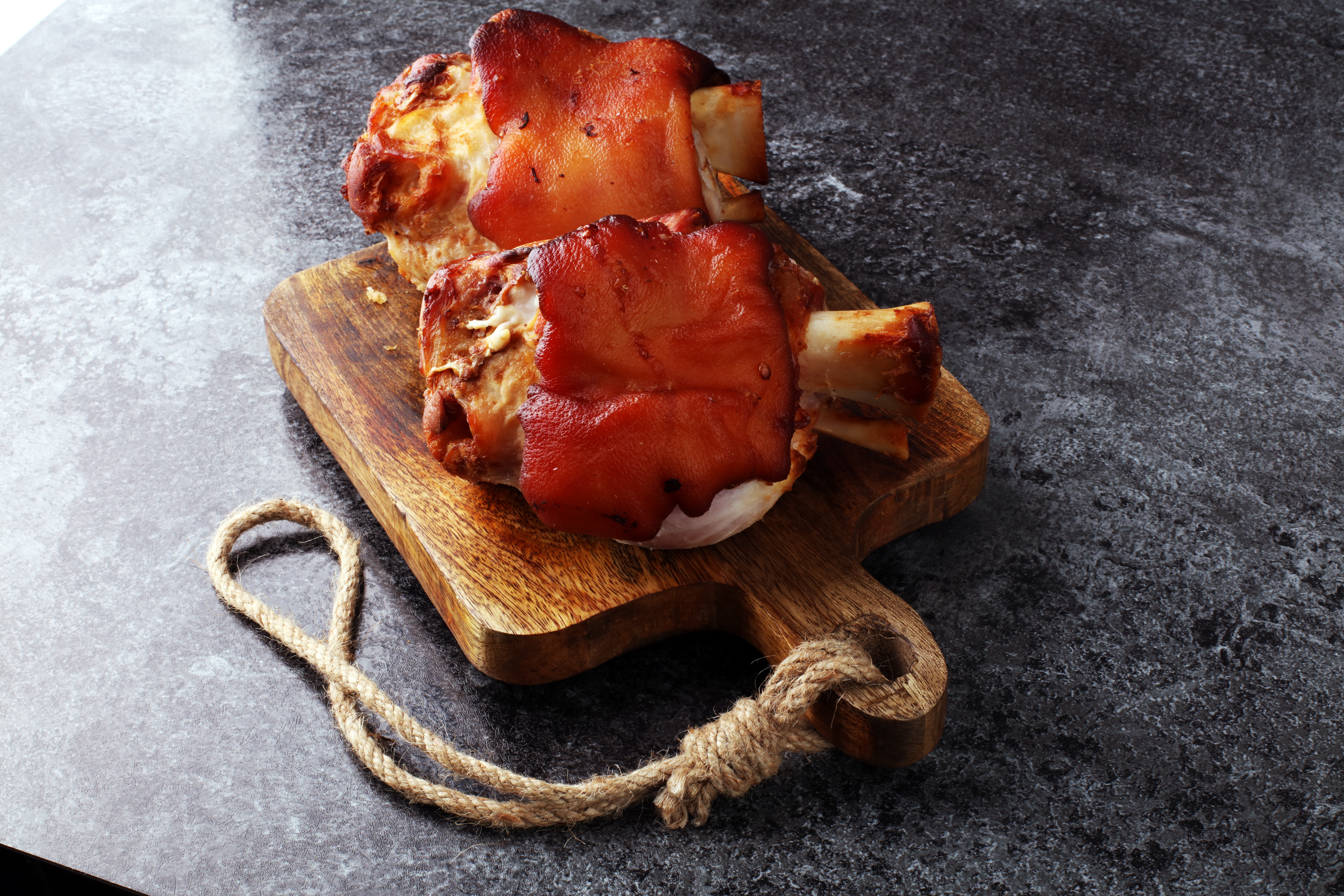 Smoked,ham,hock,with,herbs,and,spices,on,wooden,plate.