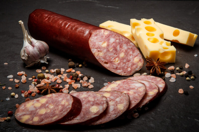 Delicatessen,sliced,cheddar,summer,sausage,with,sliced,pieces,served,with